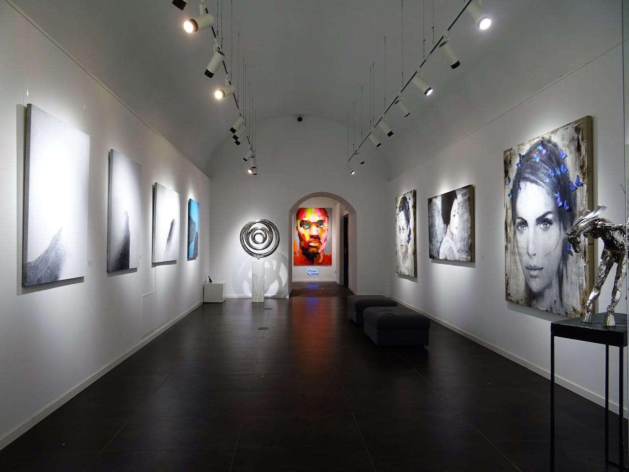 Sleek and modern art gallery with various contemporary paintings on display.